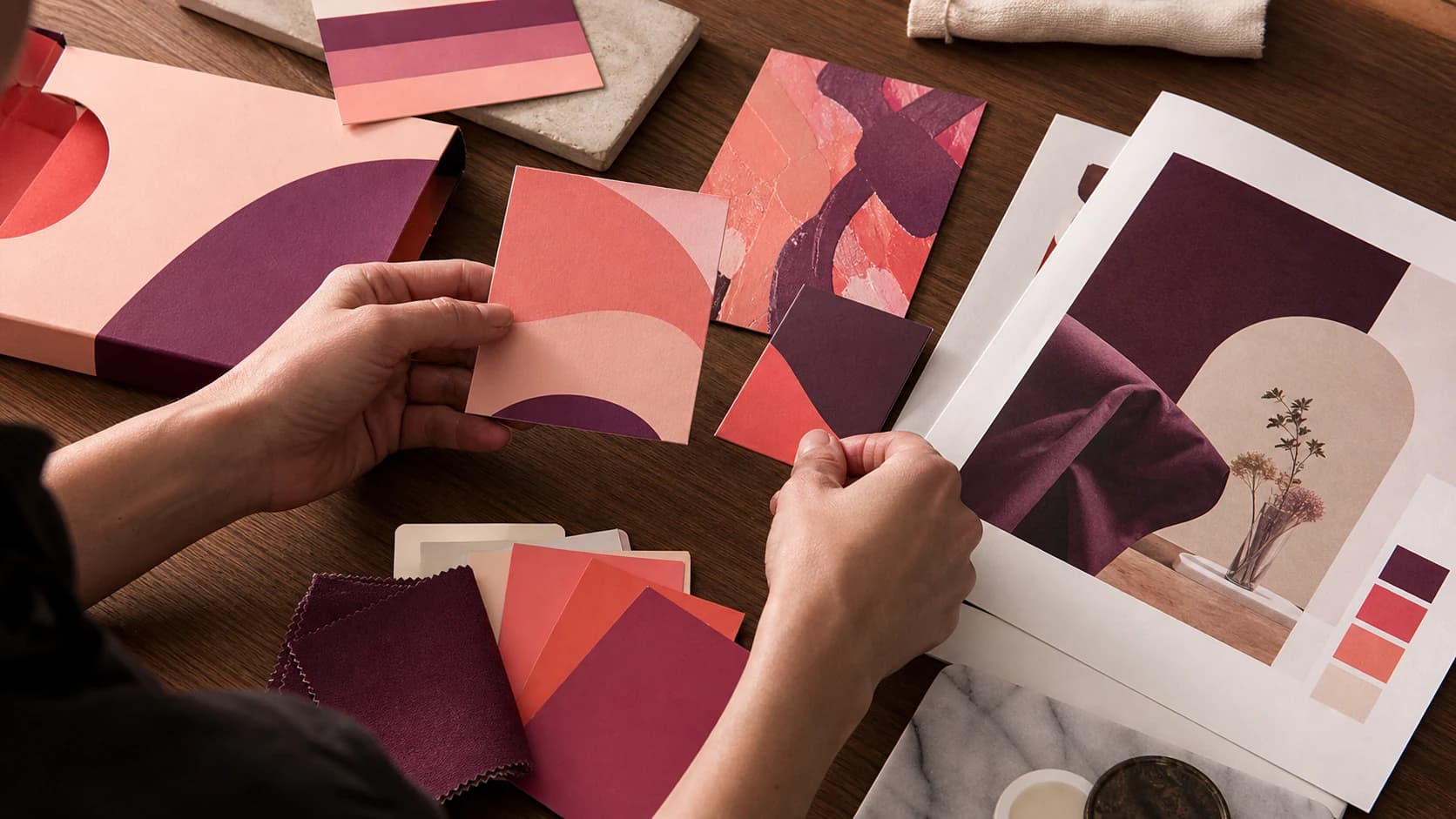 A creative director comparing varied but coordinated brand applications and colour samples