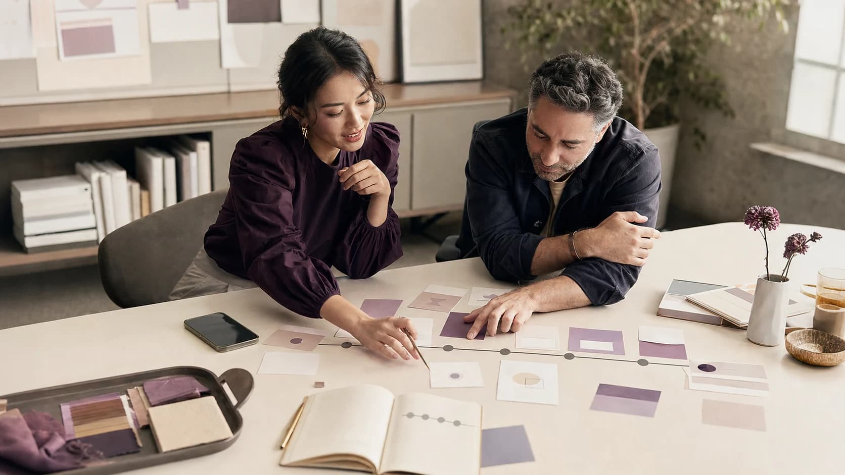 Two marketing strategists mapping a customer journey together in a contemporary studio